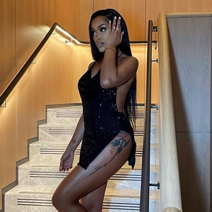 Close-up of black sequin mini dress featuring backless design and high side slit