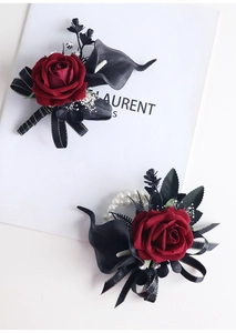 Détail de corsage rose en velours rouge et calla noir avec bracelet en perles