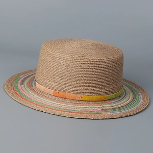 Detailed close-up of woven raffia texture and colorful striped edge on flat top sun hat