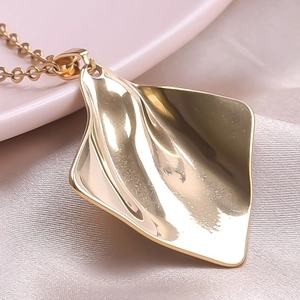 Detailed close-up of 18k gold plated geometric pendant with irregular crinkle texture