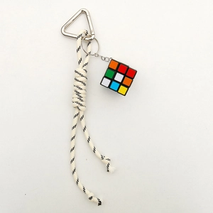 Detail of colorful mini Rubik's cube keychain with braided black and white nylon cord