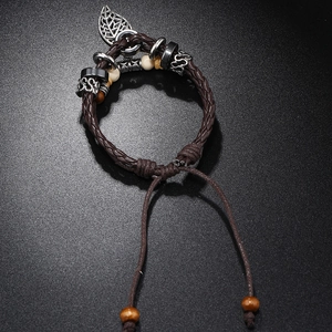 Detail of adjustable multilayer braided leather bracelet with silver leaf pendant and wood beads