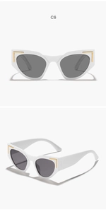Close-up of white cat-eye sunglasses with golden metal corner L-shaped accents