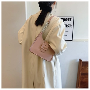 Detail of powder pink underarm bag with silver chain strap and chunky stitched edges
