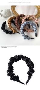 Detailed view of satin pleated headbands in various colors with silky texture