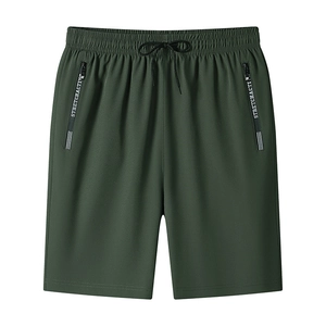 Detail of green quick-dry shorts featuring elastic drawstring waist and zip pockets