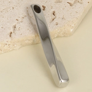 Macro view of a rectangular silver 304 stainless steel bar pendant on a stone surface