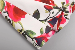 Gros plan détaillé du motif floral rose sur tissu blanc avec surpiqûres de qualité