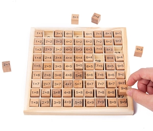 Close-up of hand placing a 9x8 wooden multiplication block into the learning board