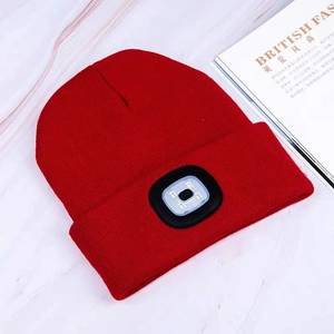 Red knit beanie with integrated LED headlamp for outdoor lighting and warmth