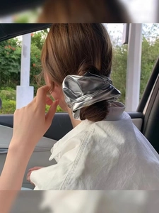 Metallic silver scrunchie hair tie detail on model with shiny ballet style finish