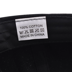 Detail of internal wash care label showing 100% cotton fabric and washing symbols on cap