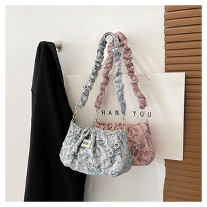 Detail of pleated cloud bags with daisy chain and textured shoulder strap in soft pastels