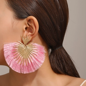 Nahaufnahme von rosa Quasten-Fächerohrringen mit goldenen Details an einem Model
