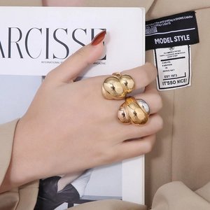 Detail of chunky gold twisted rope ring worn by model for a modern luxury fashion look