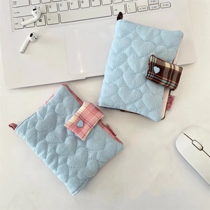 Quilted blue heart pattern book covers with button closure on a desk with laptop