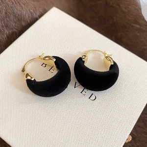 Close-up of vintage golden hoop earrings featuring high-quality black flocking texture