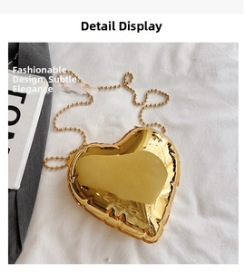 Detail of a heart-shaped gold chain bag with pleated texture and round bead strap