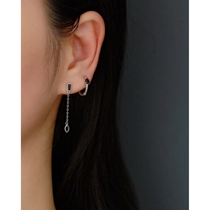 Detail of silver S925 earrings featuring black rectangular stone and fringe chain on ear