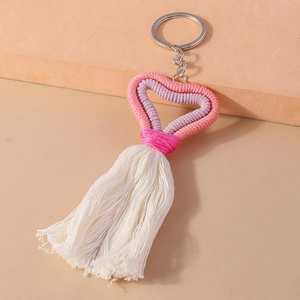 Detailed shot of pink and purple hand-knitted heart tassels on a metallic keyring