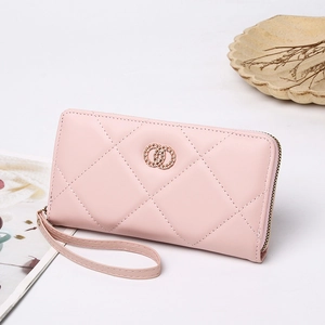 Detailed view of pink quilted long wallet featuring chain link emblem and wrist strap