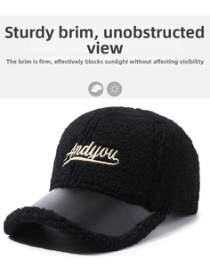 Detail of black faux shearling baseball cap with white Andyou embroidery and leather brim