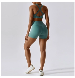 Dettaglio del reggiseno sportivo con schiena incrociata e pantaloncini da yoga ciano