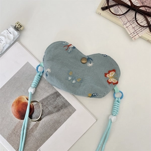 Vue détaillée d'une pochette cœur en velours côtelé avec broderie papillon et bouton