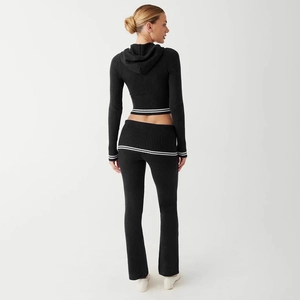 Rear view of black knit hooded crop top and flare pants set with stripe details