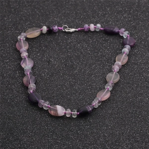 Gros plan de perles en pierres semi-précieuses violettes et roses avec texture naturelle