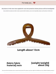 Detail view of a 13cm amber resin hair claw clip showing translucent cross design details