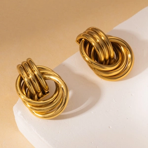 Polished chunky gold knot earrings with layered geometric hoops on stone display