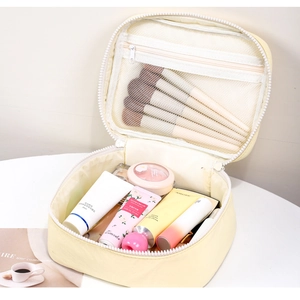 Detailed interior of macaron beige cosmetic bag showing mesh pocket and large capacity