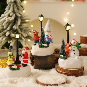 Dettaglio di miniature di Babbo Natale e pupazzo di neve in resina su base di neve