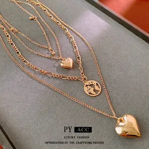 Three-layer gold pendant necklace featuring heart charms and a world map medallion