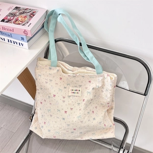 Detail of cute cat printed canvas tote bag with bow patterns and blue fabric handles