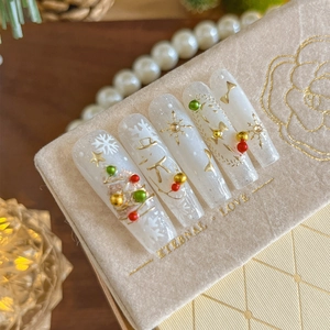 Christmas snowman press-on nails with gold foil and red ribbon accents on fabric box