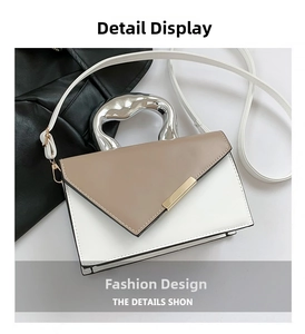 Detail of color-block handbag featuring a unique silver irregular metal handle and gold clasp
