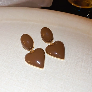Close-up of vintage brown enamel heart earrings with elegant gold-rimmed borders