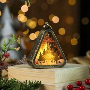 Close-up of a bronze Christmas lantern with a warm LED scene and Merry Christmas print