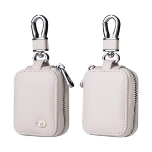 Detail view of off-white leather case with silver carabiner and musical note emblem