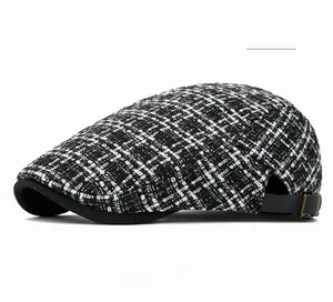 Detail of off-white tweed flat cap featuring side adjustable buckle and bronze hardware