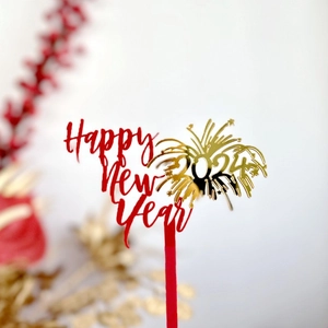 Detail of red and gold acrylic Happy New Year 2024 cake topper with festive decorations