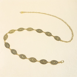 Detail of vintage gold metal chain belt with embossed oval plates for women's dresses