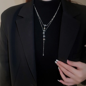 Detail of double-layer stainless steel star necklace with tassels and zircon stones