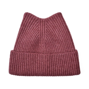 Macro detail of the wine red ribbed knit texture and cute cat ear design on the winter hat