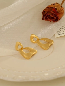 Vintage matte gold irregular geometric hollow drop earrings on a white aesthetic background