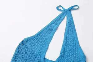 Detailed view of the halter neck tie and blue crochet knit texture on a summer dress