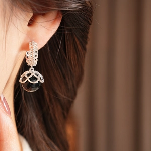 Detail of vintage French style gold plated pearl earrings with black beads on model