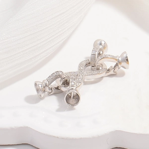 Macro shot of S925 silver pearl connector with cubic zirconia and four cup settings